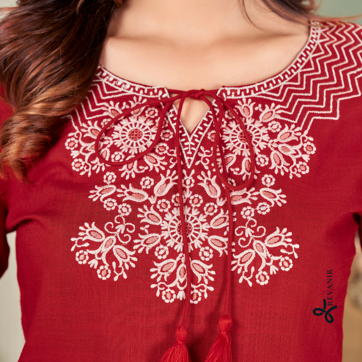Close-up of Revanir deep maroon office tunic highlighting the  V-split neckline, crisp white yolk embroidery, and subtle tassel tie-ups.